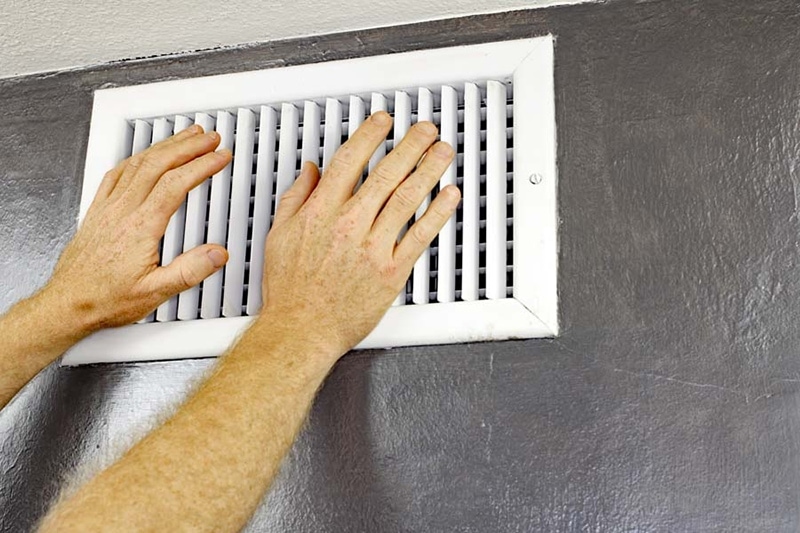 two hands on white wall vent