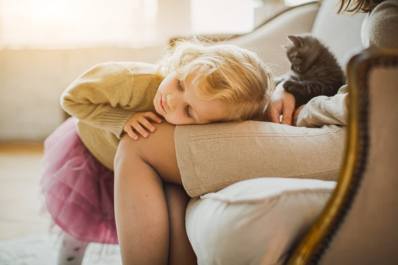 The Basics of Winter Indoor Air Quality. A girl laying on her mothers lap.