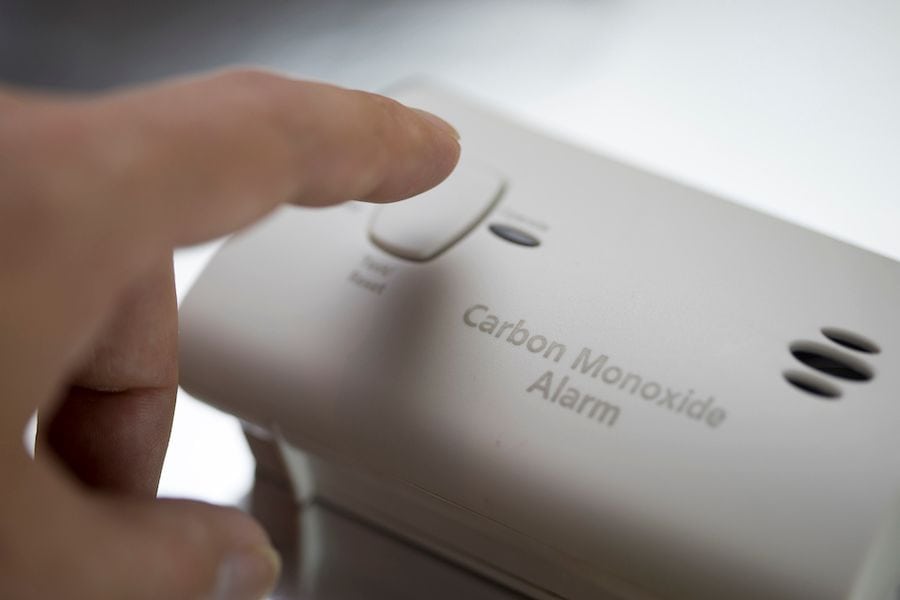 A person presses a CO alarm